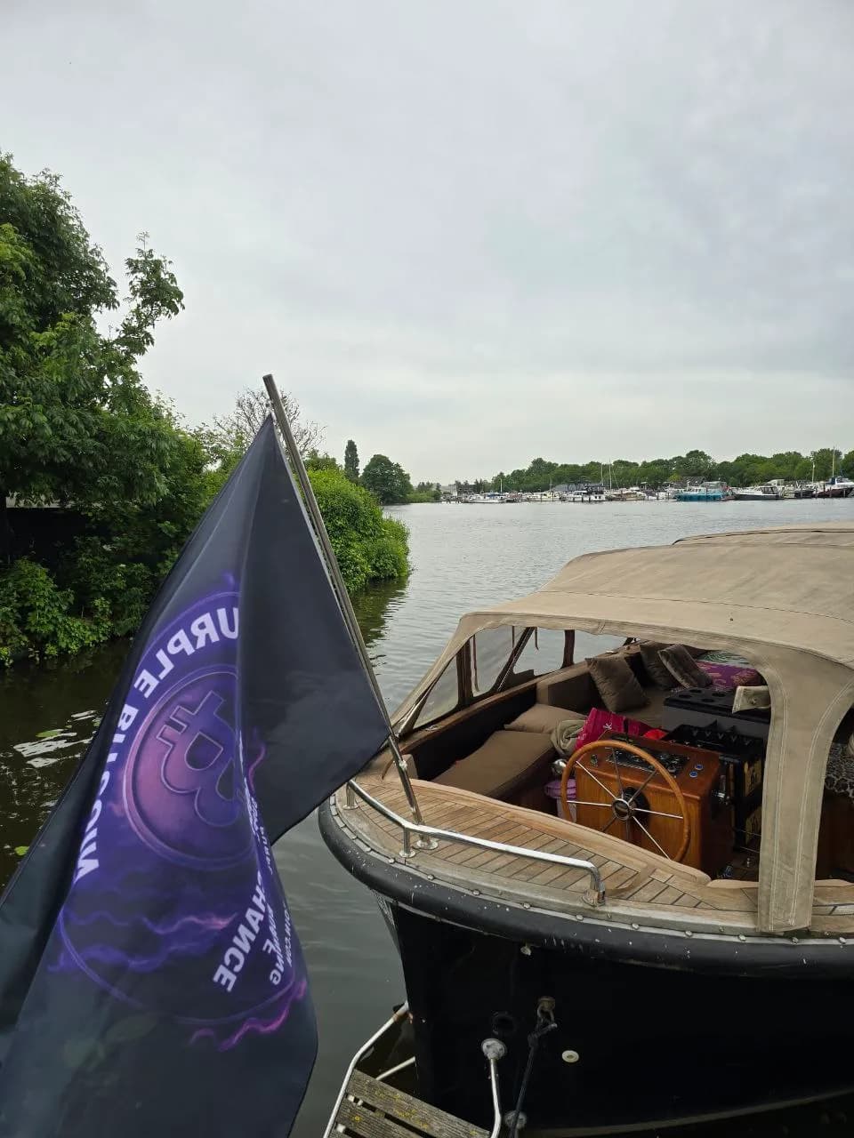 Purple Bitcoin logo on a flag during a boat community activation